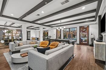A modern clubroom with a grey sofa and a coffee table. at 1010 Dilworth Apartments, North Carolina, 28204